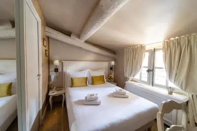 a bedroom with a large white bed and a window at Les Quatre Dauphins in Aix-en-Provence