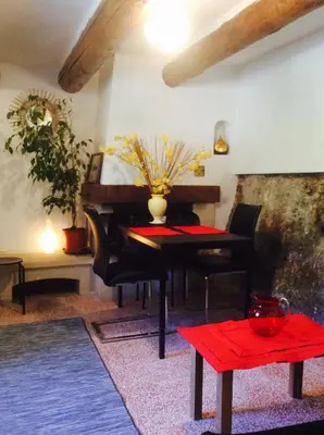 a living room with a piano and a red table at Fontaine-de-Vaucluse : maison avec vues in Fontaine-de-Vaucluse
