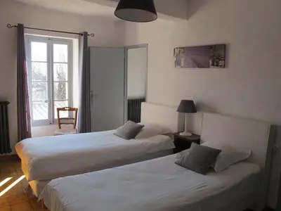 two beds in a hotel room with a window at Le Guintrand in Bédoin