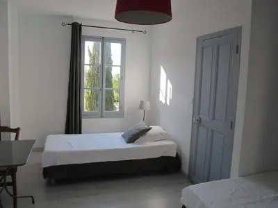 a bedroom with two beds and a window at Le Guintrand in Bédoin