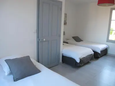 two beds in a room with white walls and white floors at Le Guintrand in Bédoin