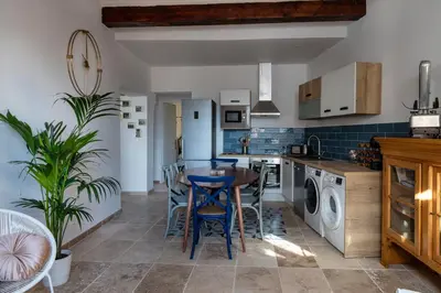 a kitchen with a table and chairs in a room at La terrasse de Tiss in Bédoin