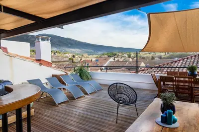 a balcony with chairs and tables and a view at La terrasse de Tiss in Bédoin