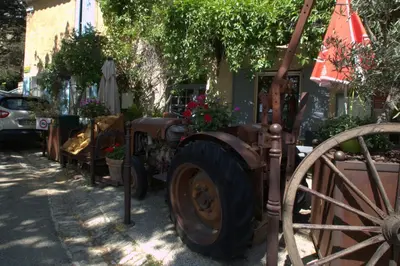an old tractor parked in front of a building at Luxurious Provencal Village House, Walk to Village Pool in Rustrel