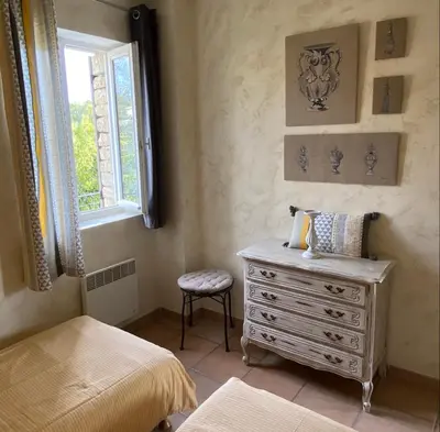 a bedroom with a bed with a dresser and a mirror at Bastidon à Gordes avec piscine in Gordes