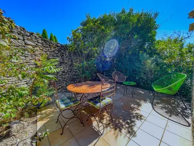 a swimming pool in a yard with chairs and trees at Bastidon à Gordes avec piscine in Gordes