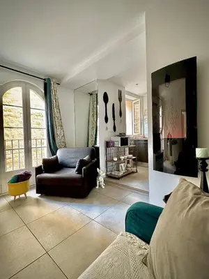 a living room with a couch and a chair at Petit Rêve in LʼIsle-sur-la-Sorgue
