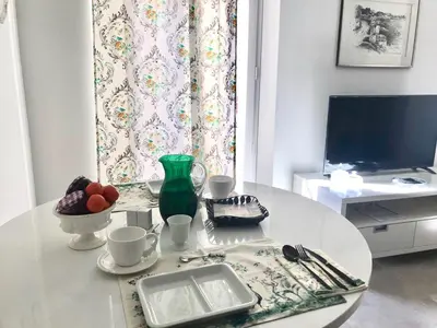 a white table with a bowl of fruit and a television at Petit Rêve in LʼIsle-sur-la-Sorgue