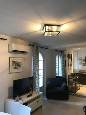 a living room with a couch and a tv at Petit Rêve in LʼIsle-sur-la-Sorgue