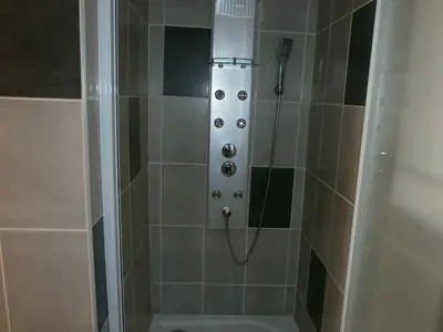 a shower with a glass door with a shower head at Pervenches in Jonquerettes