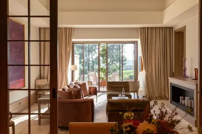 a living room with a couch and chairs and a fireplace at Coquillade Provence - Relais & Châteaux in Gargas