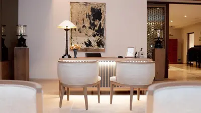 a bar with two white chairs and a lamp at Coquillade Provence - Relais & Châteaux in Gargas