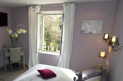 a bedroom with a bed and a window at La Bastide de Venelles in Venelles