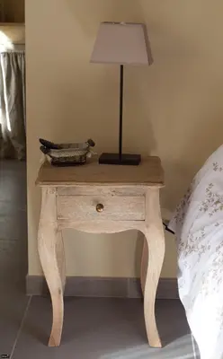 a table with a lamp on it next to a bed at La Bastide de Venelles in Venelles