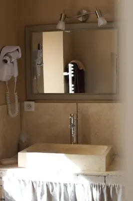 a bathroom sink with a mirror and a phone at La Bastide de Venelles in Venelles