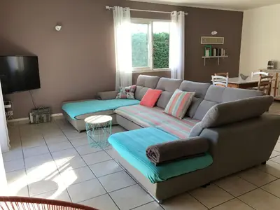 a living room with a couch and a tv at Villa Zénitude in Cabannes