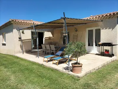 a patio with two chairs and a table in front of a house at Villa Zénitude in Cabannes