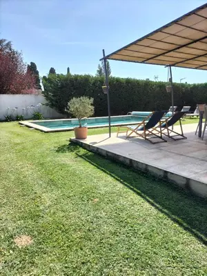 a patio with two chairs and a swimming pool at Villa Zénitude in Cabannes