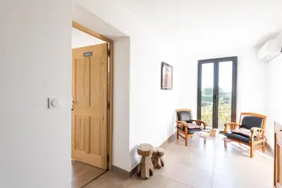 a hallway with two chairs and a door with windows at chez nico in Bédoin