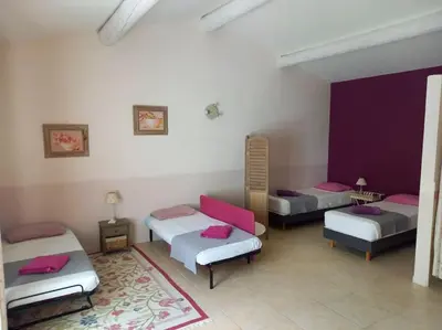 a room with three beds and a rug at Le Mas de l'Escaillon in Saint-Saturnin-les-Apt