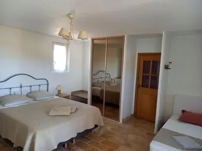 a white bedroom with two beds and a mirror at Le Mas de l'Escaillon in Saint-Saturnin-les-Apt
