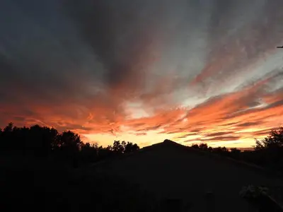 a sunset in the sky over a house at Le Mas de l'Escaillon in Saint-Saturnin-les-Apt