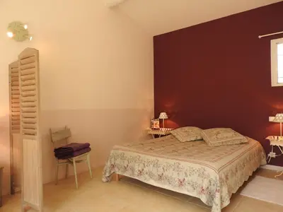 a bedroom with a bed and a black wall at Le Mas de l'Escaillon in Saint-Saturnin-les-Apt