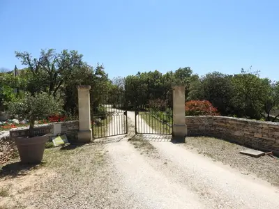an entrance to a garden with a wrought iron gate at Le Mas de l'Escaillon in Saint-Saturnin-les-Apt