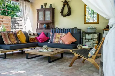 a living room with a blue couch and colorful pillows at Gîtes Domaine des Machottes in Grans