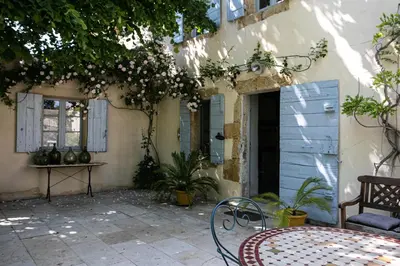 a patio with a table and chairs in front of a building at Gîtes Domaine des Machottes in Grans