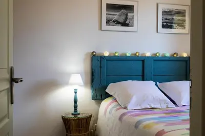 a bed with a blue headboard in a bedroom at Gîtes Domaine des Machottes in Grans