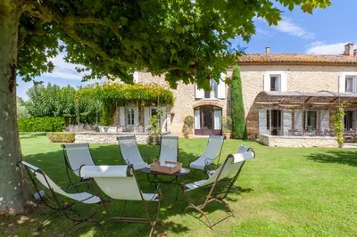a group of chairs and a table in front of a house at Mas de Canfier in Robion en Luberon