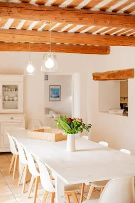 a white dining room with a white table and chairs at Mas de Canfier in Robion en Luberon