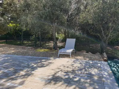 a white chair sitting in the middle of a yard at le Gecko en Provence in La Roque-sur-Pernes