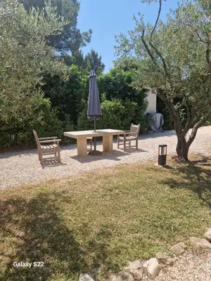 a picnic table with an umbrella and two benches at le Gecko en Provence in La Roque-sur-Pernes