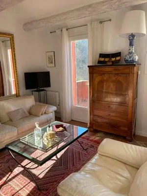 a living room with a couch and a table at Villa des Roses in Roussillon