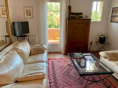 a living room with a white couch and a glass table at Villa des Roses in Roussillon