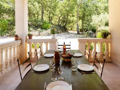 a wooden table with plates and glasses on a porch at Ménerbes Home with Private Pool in Ménerbes