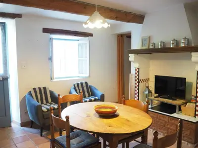 a living room with a table and chairs and a television at Sunny Provence Home with Terrace in Monteux