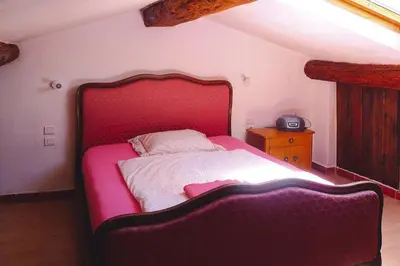 a bedroom with a bed with a red head board at Cozy Noves Home with Pool Access in Noves