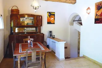 a dining room with a table and a counter at Cozy Noves Home with Pool Access in Noves