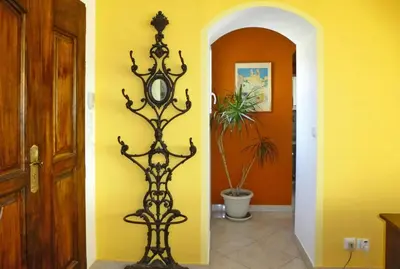 a clock in a room with a yellow wall at Premium villa with garden and pool, Lambesc in Lambesc