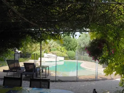 a pool with chairs and a table next to a fence at Premium villa with garden and pool, Lambesc in Lambesc