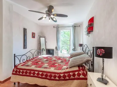 a bedroom with a bed and a ceiling fan at Holiday Home Mas de L'Oulivier by Interhome in Roussillon