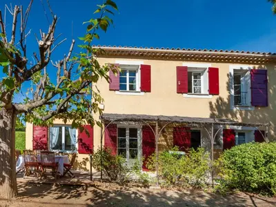 an old house with red shutters and a yard at Holiday Home Mas de L'Oulivier by Interhome in Roussillon