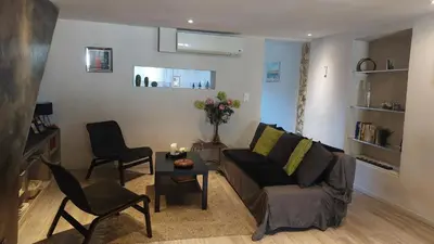 a living room with a couch and a table and chairs at Côté Terrasse in Apt