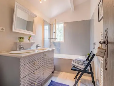 a bathroom with a sink and a chair in it at Holiday Home Les Iris by Interhome in Gargas