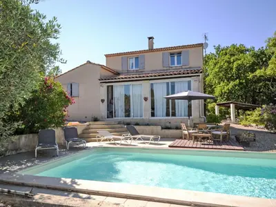 a villa with a swimming pool in front of a house at Holiday Home Les Iris by Interhome in Gargas
