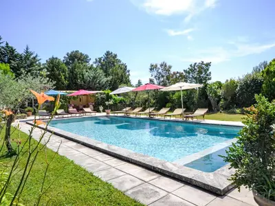 a swimming pool with chairs and umbrellas at Holiday Home L'Olivier by Interhome in Lagnes