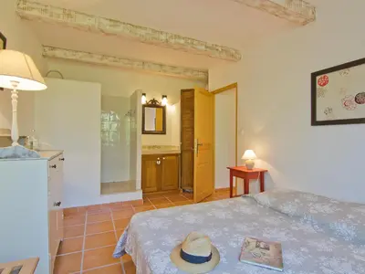 a bedroom with a bed with a hat on it at Holiday Home L'Olivier by Interhome in Lagnes